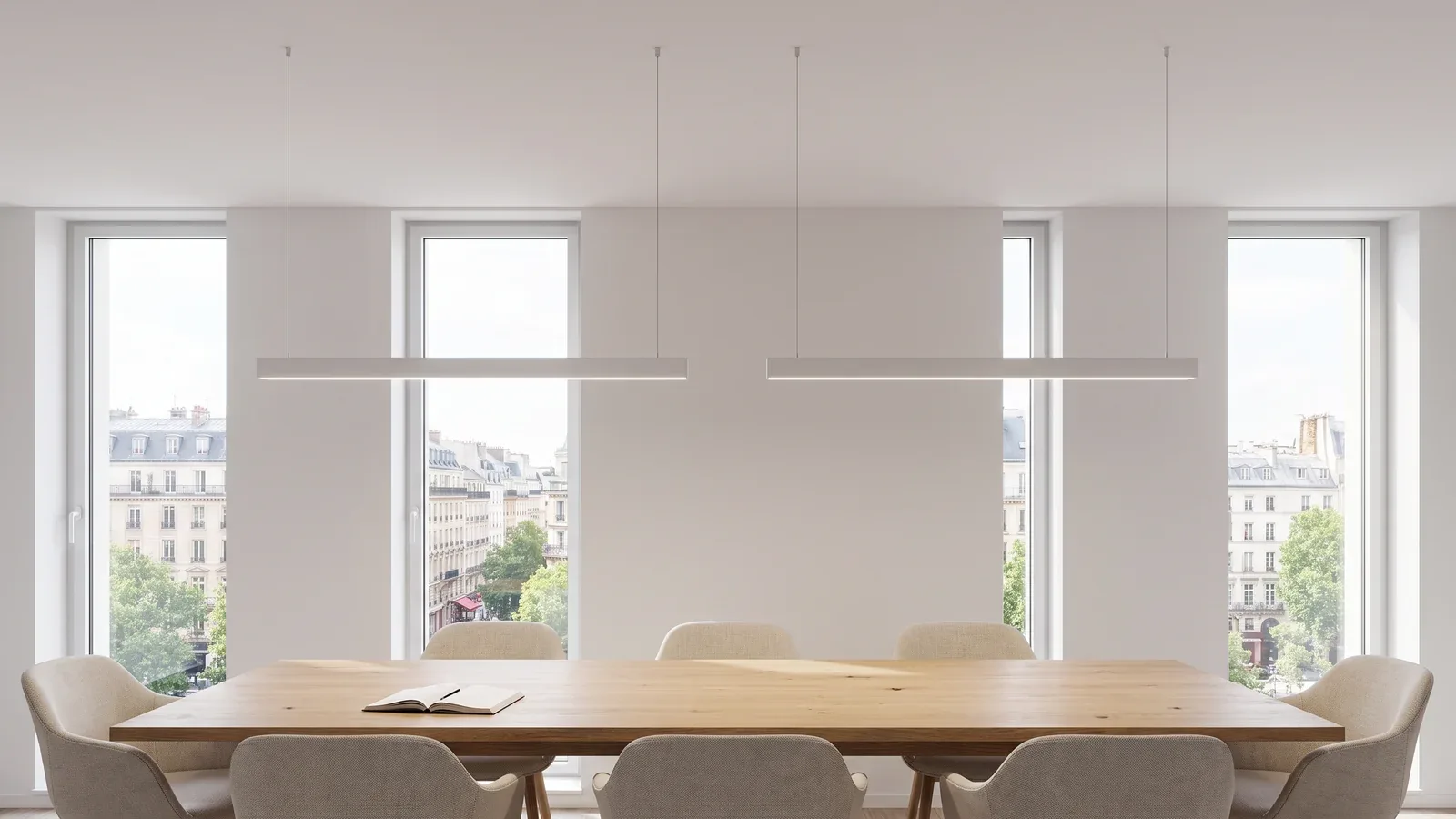 Salle de réunion contemporaine avec luminaires linéaires blancs suspendus par de fins câbles au-dessus d’une table en chêne.